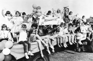 Children from Peppermint Dancing School wave during the Clacton Carnival, Clacton-on-Sea, UK, 1980s