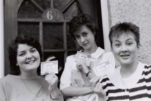 Three friends holds up their tickets to Live Aid, on the morning of the concert, Wembley, UK, 1985